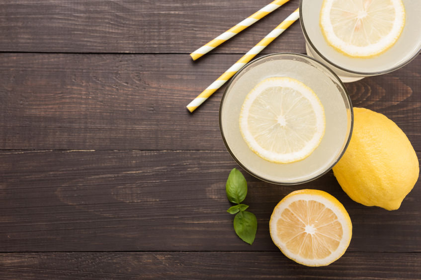 lemonade with fresh slice lemon on wooden background.